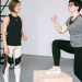 Fitness coach guides a woman in workout indoors. Focus on exercise and healthy lifestyle.